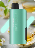 Green vape device with black accents on a blurred background of tea and flowers